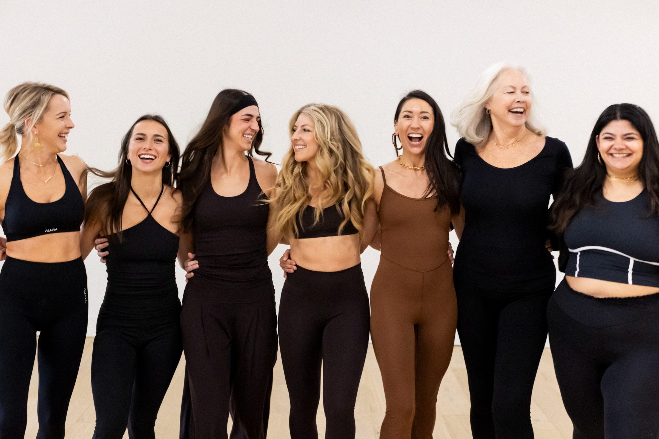 The Refine Pilates & Yoga instructors laughing together in the studio