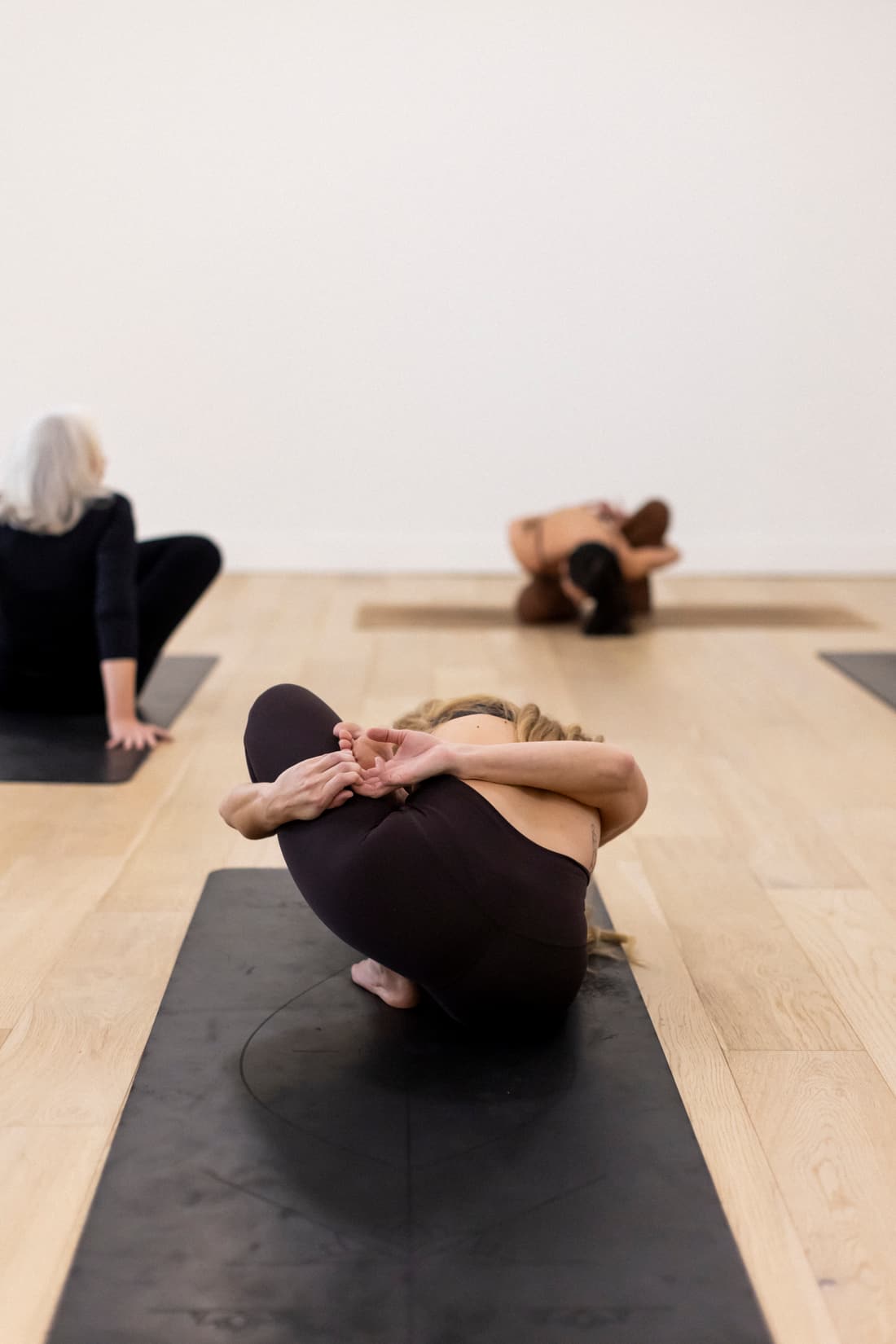 A student folded into a deep seated stretch